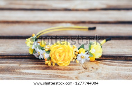 Handmade hoop Yellow flowers. Yellow hair band on wooden background.