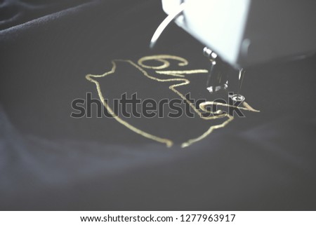 Embroidery machine stitching 2019 chinese new year motive with precious gold yarn on black velvetely fabric in dark misty light mood - backside view - season gift concept