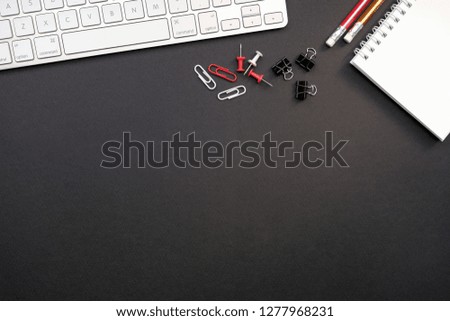 Top view with copy space of an office table with business objects for a work. Black paper background.