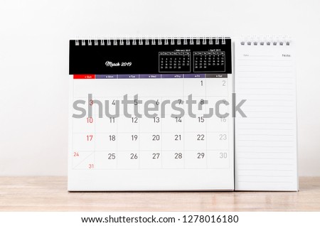 2019 March calendar on wooden background with note paper.