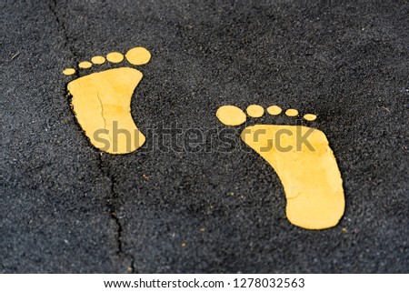a yellow feet on the street indicating a path for walkers