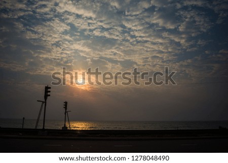 Sunset along a railway track aligning the beach 