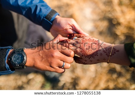Young and happy couple holding hands. Man or boy and girl holding their hands. The girl's han has henna. Asian couple love each other.