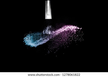 Cosmetic brush with purple and blue ocean cosmetic powder spreading for makeup artist or graphic design in black background, look like a lively and joyful mood.