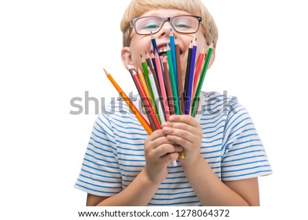 Isolated child with pencils. Adorable kid on white background. Portrait of funny blonde boy with colorful pencils.