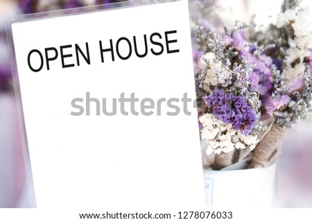 Open house word on card and purple flower background.