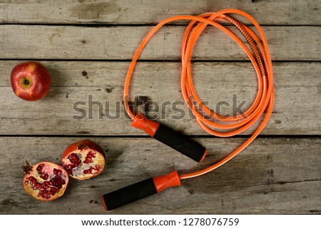 Jumping rope and fruits on wooden background