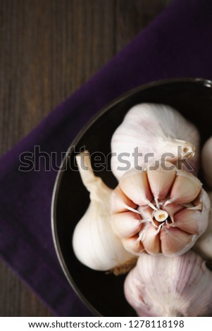 Garlic and garlic cloves in selective focus on dark background.