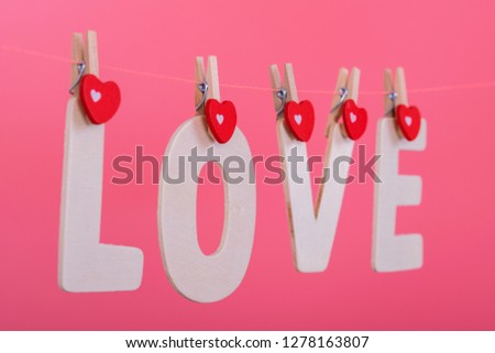 Word LOVE hang on pink color background, valentine