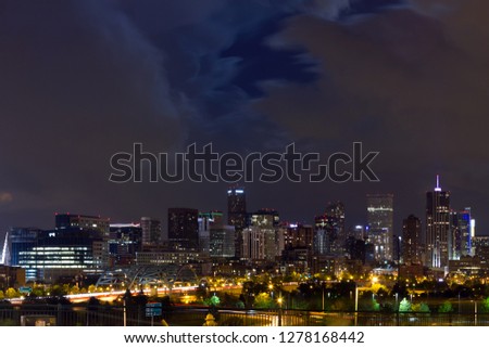 Denver Colorado downtown city skyline at night with clouds overhead