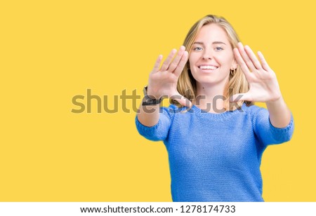 Beautiful young woman wearing blue sweater over isolated background Smiling doing frame using hands palms and fingers, camera perspective