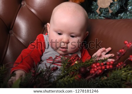 cute newborn baby in red and gray jumpsuit