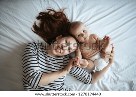 Gentle mother hipster and baby 6 months, tenderness and care, top view. The concept of motherhood and happiness with the baby. Single mom and baby