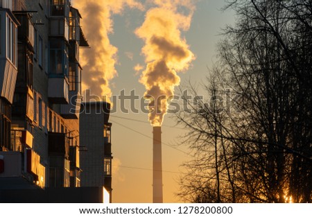 Pollution of the city from factories. Several factory pipes smoke and pollute the city. Ecology problem