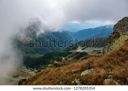 rocky Tatra mountain tourist hiking trails under blue sky and occasional mist  cloud in Slovakia, path to Volovec mountain