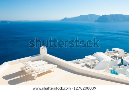 Two chaise lounges on the terrace with sea view. Santorini island, Greece