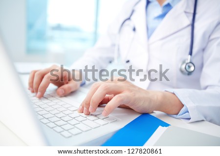 Modern clinician inputting diagnosis into an online data base Royalty-Free Stock Photo #127820861