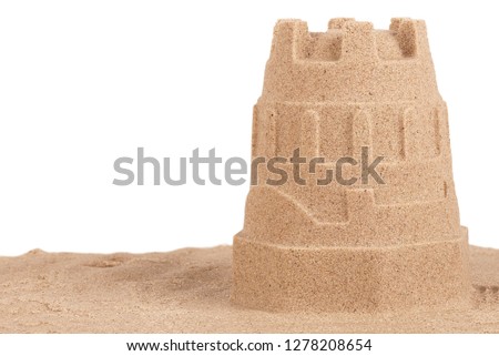 Close up on a sand castle on the beach, isolated on white background. Travel concept. Copy space for your text or image.