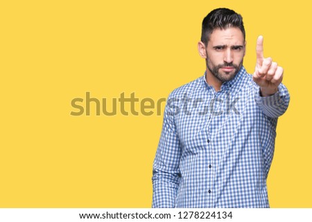 Young handsome man over isolated background Pointing with finger up and angry expression