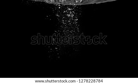 Close-up images of soda water bubbles floating up to top of water surface which little and big circle texture splashing up by gas power in carbonate drink make refreshing moment on black background Royalty-Free Stock Photo #1278228784