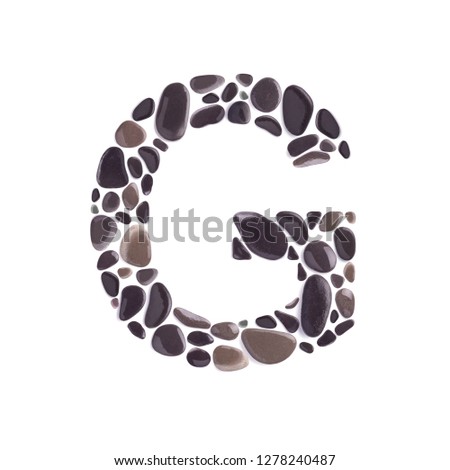 G Letter made of beach stones isolated on white background