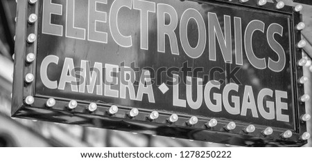 Electronics camera luggage shop sign.