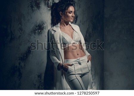 Beautiful young girl in white dress. Posing for a photographer in the studio. Stylish photo zone in creative colors.