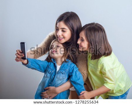 three sisters posing and taking selfies in the studio.