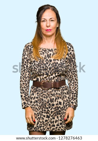 Beautiful middle age woman wearing leopard animal print dress Relaxed with serious expression on face. Simple and natural looking at the camera.