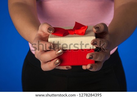girl gives a red box with a gift, a red box in her hands