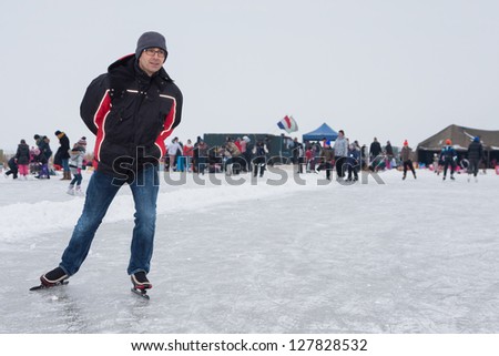 Man skating on the icerink of Eemdijk (Holland) Royalty-Free Stock Photo #127828532