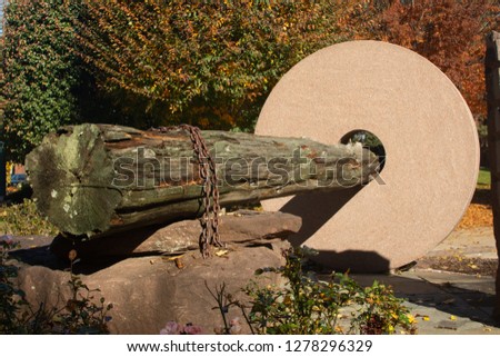 Stone and wooden log structure in a park on a sunny autumn day