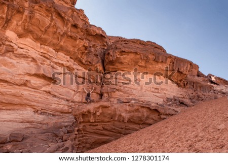 A young woman posing on the red rock in Wadi-Rum desert, Jordan.