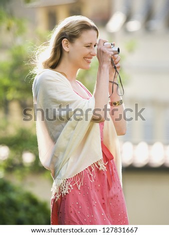 Woman taking a photograph outdoors