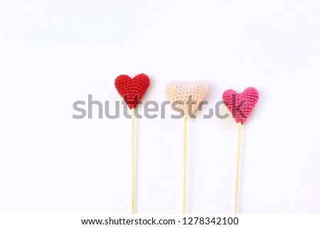 Saint Valentine concept. Three knitted heart on white background.