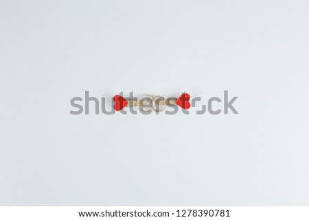 wedding rings on clothespins with hearts on white background