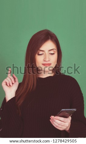 young woman girl holding smart phone  isolated on green