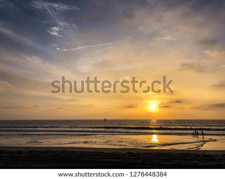Sun sets over Venice Beach, CA with moody sky 