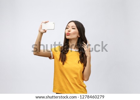 Image of excited happy young woman isolated over grey background make selfie by camera.