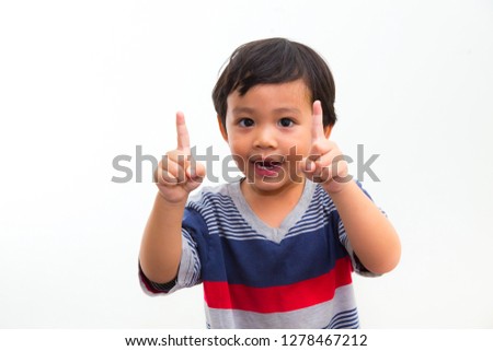 Portrait of Cute little boy pointing up on white background