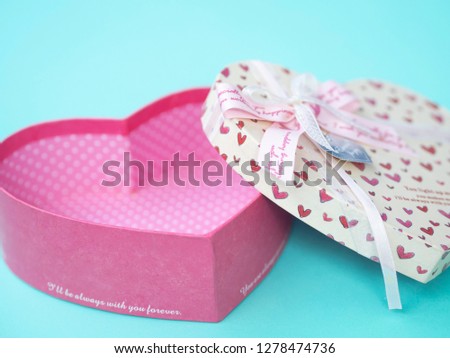Empty Pink Heart shape box have bow on lid put on blue pastel background , image using for valentine gift and lovely gift concept