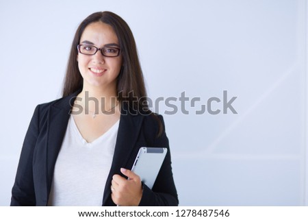 Portrait of smiling young business woman with digital tablet in her hands.