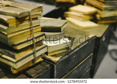 Stack of old books stored in disrepair on an old vintage trunk.