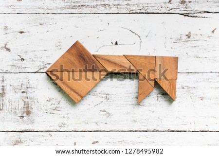 Tangram puzzle in key shape on old white wood background