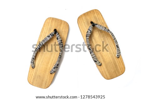 Close up old used wooden Japanese sandal isolated on white background. It is a form of traditional Japanese footwear that resemble both clogs and flip-flops.