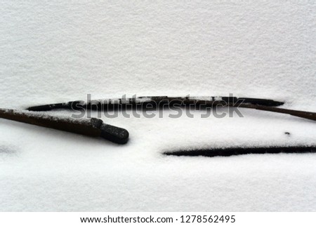 Photo background with snow-covered car windshield with wipers