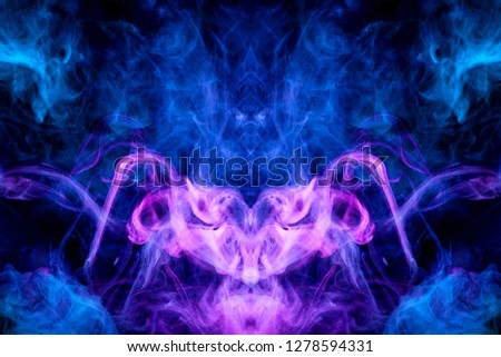 Fantasy print for clothes: t-shirts, sweatshirts.  Colorful pink and  blue smoke in the form of a skull, monster, dragon on a black isolated background. Background from the smoke of vape
