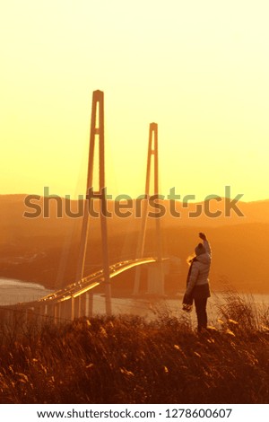 Girl on the background of the bridge and sunset                               