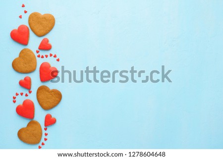 Red heart shaped cookies on blue background. Valentine's Day background with space for text.