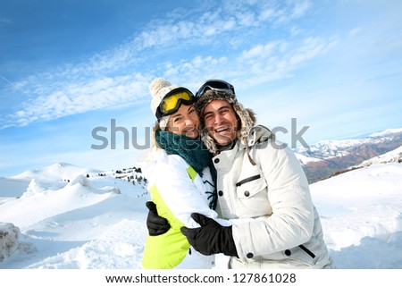 Cheerful couple standong on mountain peak